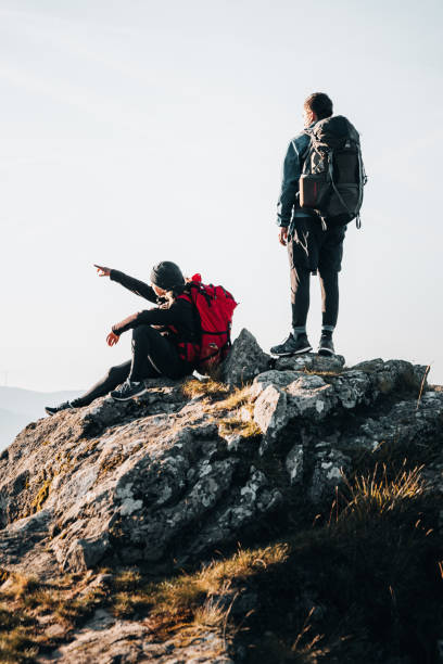 istock Young couple with backpacks relax on a mountain summit 1369653733