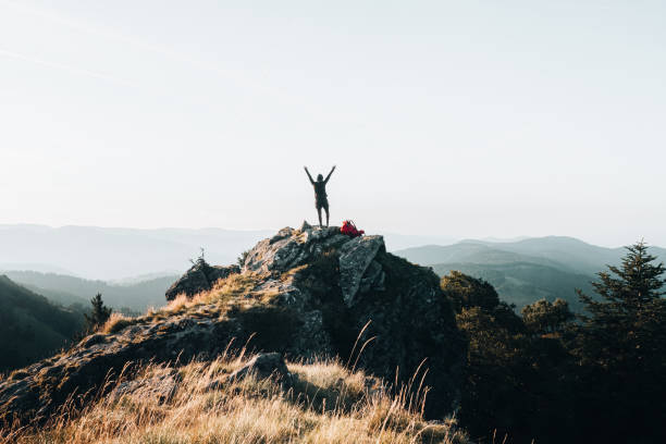 istock Backpacker celebrates on mountain summit at sunrise 1369653735