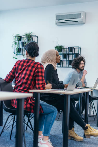 istock Multi-ethnic business group listening to a speaker while attending a business seminar at a modern workshop. 1369653841
