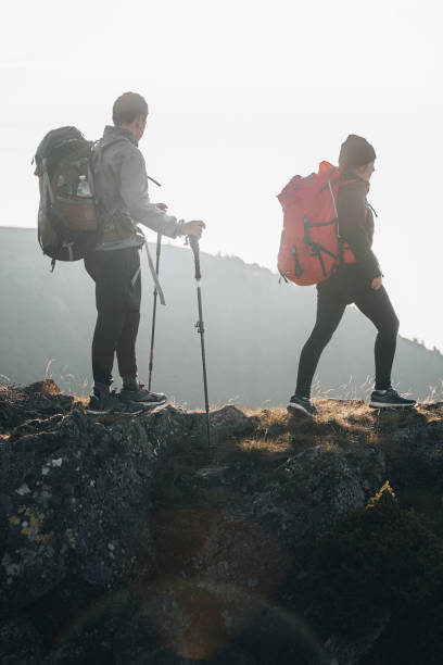 istock Young couple with backpacks relax on a mountain summit 1369653934