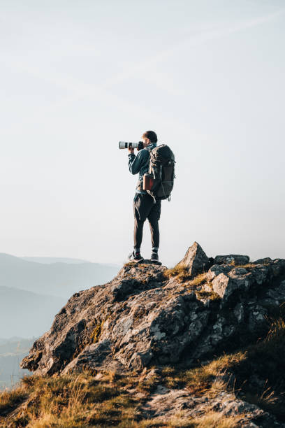 istock Backpacker takes photo from mountain summit 1369653980