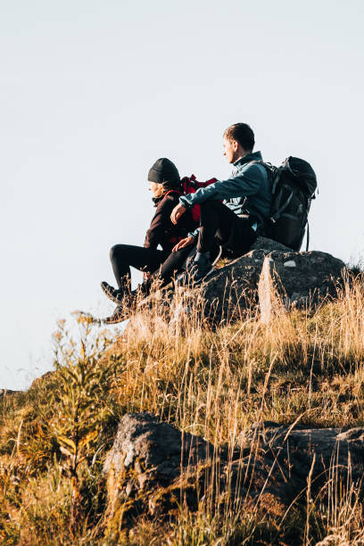istock Young couple with backpacks relax on a mountain summit 1369654029