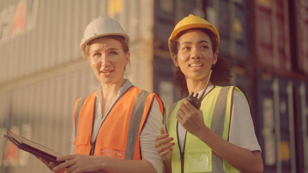istock Two female shipping working and checking container in the port 1369665735