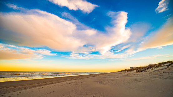 Big sky over sandy beach and ocean in North Carolina. Outer Banks at sunrise