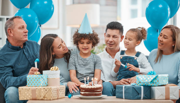 scatto di una famiglia felice che festeggia un compleanno a casa - birthday family party cake foto e immagini stock