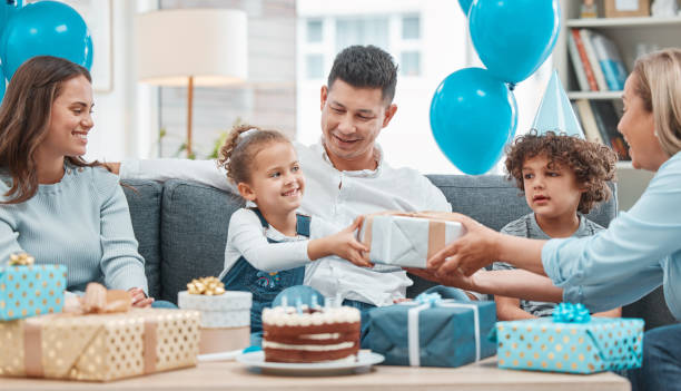 shot of a happy family celebrating a birthday at home - grandmother giving gift child imagens e fotografias de stock