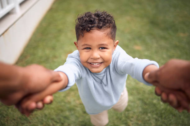 庭で手で振られている愛らしい小さな男の子のショット - swing child swinging front or back yard ストックフォトと画像