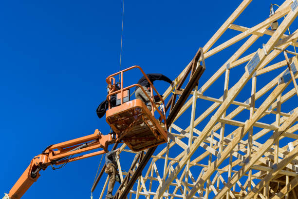 istock Construction carpenter roofer worker nailing wood beams with hammer on roof installation 1369673651