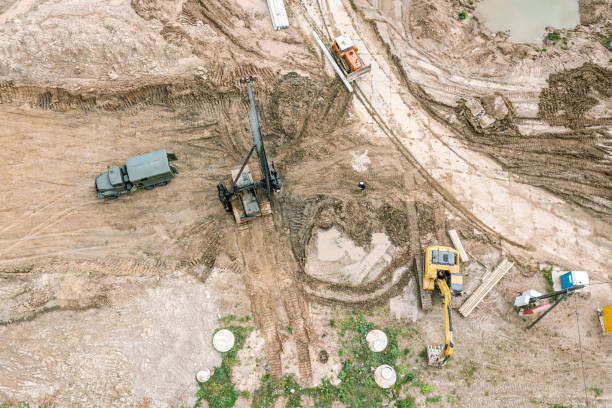 istock hydraulic hammer pile driving machine standing at construction site and ready for work. aerial overhead view. 1369677112