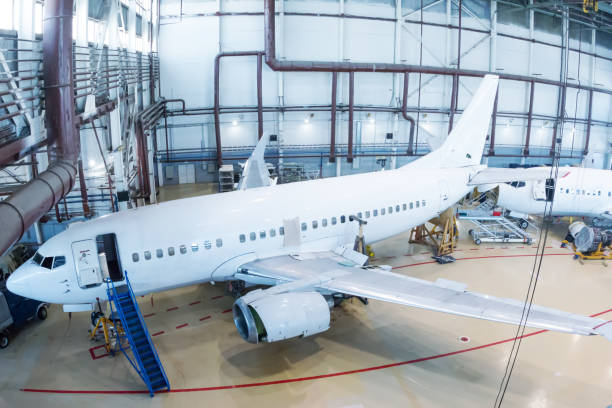 istock White passenger jet planes in the hangar. Checking mechanical systems for flight operations 1369679550