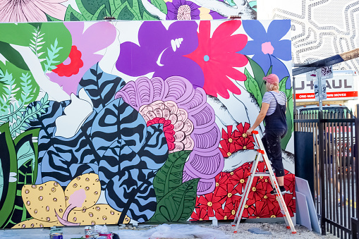 Miami, United States of America - November 30, 2019: The artist working at Art Wynwood in Miami, USA. Wynwood is a neighborhood in Miami Florida which has a strong art culture presence and murals can be seen everywhere.