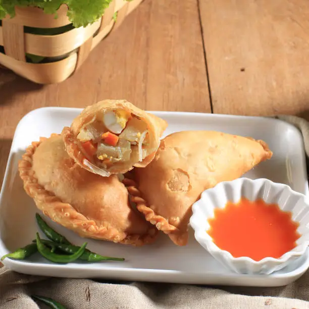 Photo of Kue Pastel Goreng (Jalangkote or Karipap)  is Flaky Pastry Snack Filled with Cubed Carrots, Potatoes, and Eggs.