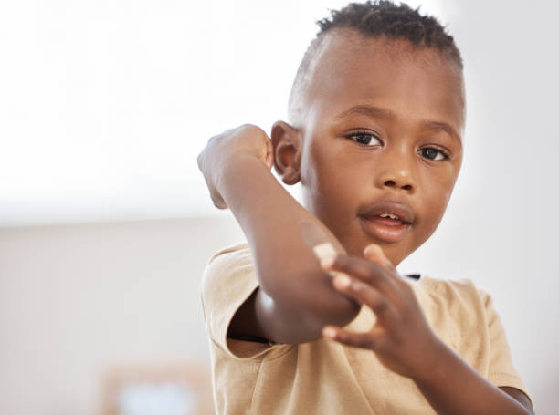снимок очаровательного маленького мальчика, прикладывающего пластырь к руке - medical dressing фотографии стоковые фото и изображения