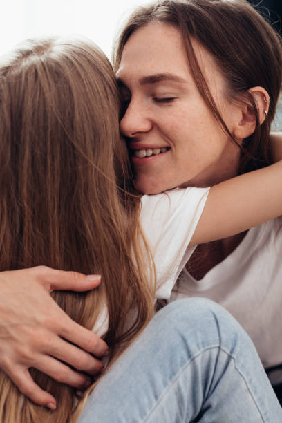 istock Happy mother and daughter hugging with eyes closed 1369683870