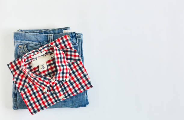 stack of plaid shirt and jean on white background, copy space
