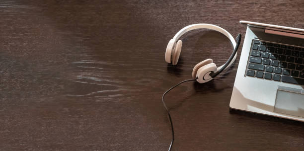 istock Home office, headset on a laptop, wooden table. Call center, customer support, help desk 1369690685