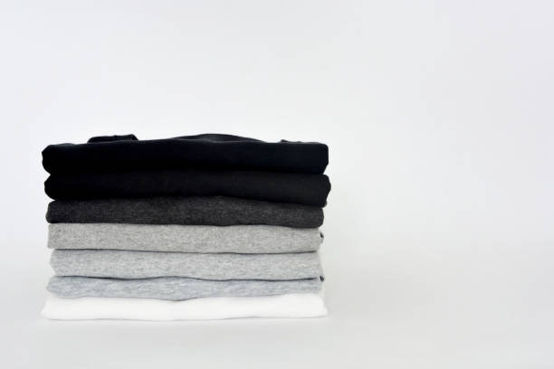 istock stack of folded black, grey and white color (monochrome) t-shirts on white background, copy space 1369691606