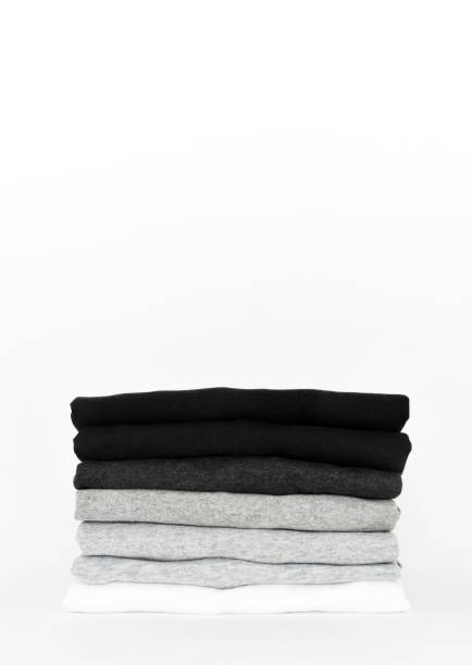 istock stack of folded black, grey and white color (monochrome) t-shirts on white background, copy space 1369691622