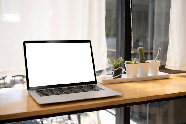 istock Mockup computer laptop with white blank display on wooden table. 1369691742