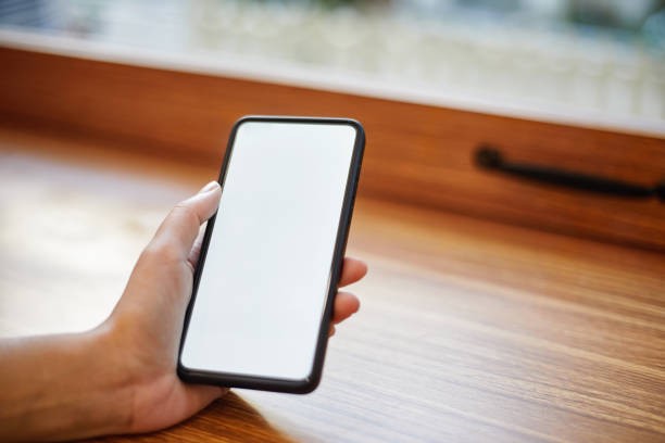 istock Close-up of hand using mobile phone on table 1369692986