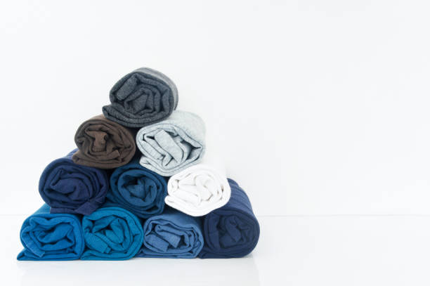 istock stack of t-shirts rolled up on white background, copy space 1369694181