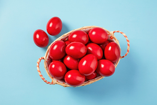 Basket with Red Easter Eggs on Blue Background