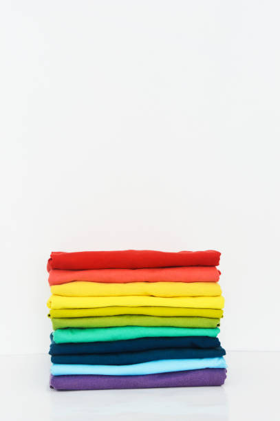 istock stack of colorful t-shirts on white background, copy space 1369696694