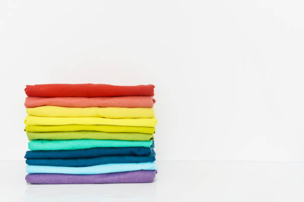 stack of colorful t-shirts on white background, copy space