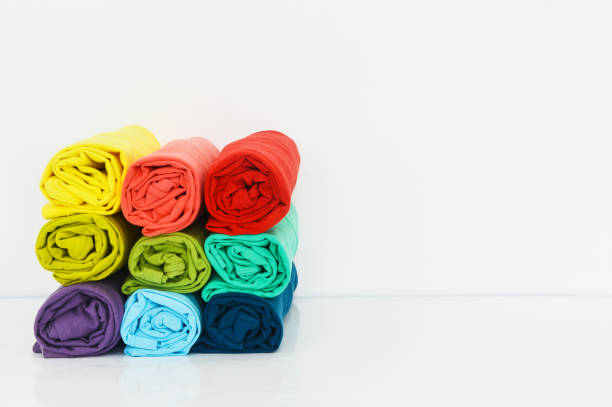 istock stack of colorful t-shirts rolled up on white background, copy space 1369696763