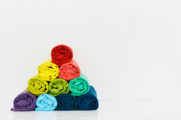 istock stack of colorful t-shirts rolled up on white background, copy space 1369696787