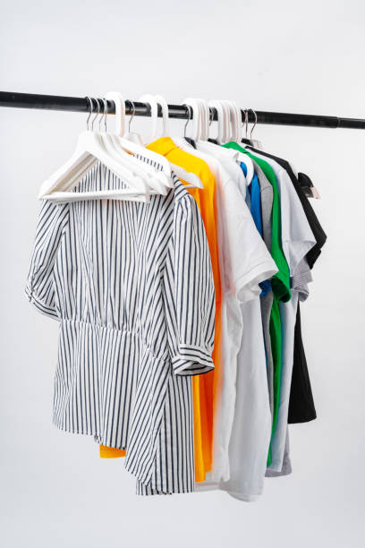 istock Clothes hang on clothing rack over white background. 1369699361