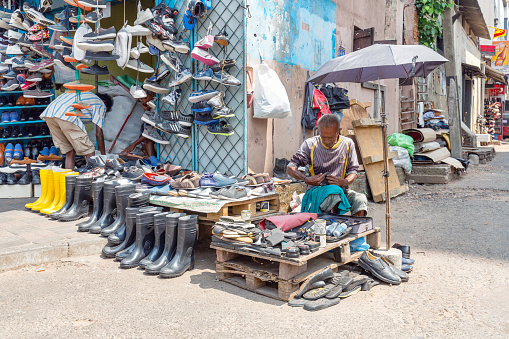 Colombo, Sri Lanka - February 5, 2020: A shoemaker repairs shoes on the street in Colombo