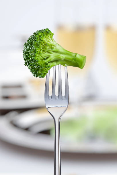 A piece of raw broccoli on the tip of the fork. stock photo
