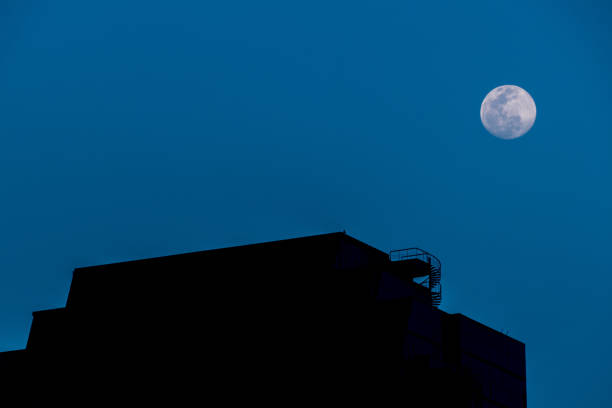 istock Full moon over the silhouette building 1369702290