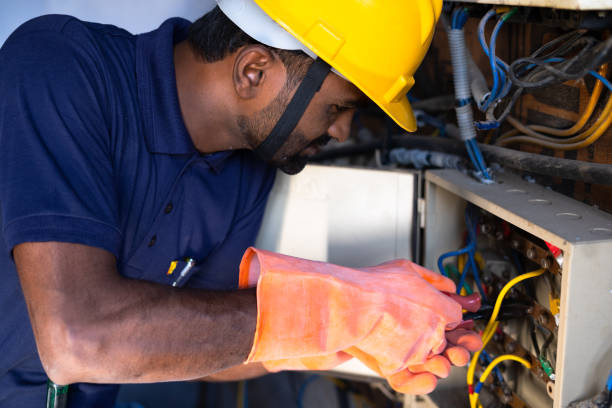 Focus on hand, young electrical engineer with protective workwear repairing or connecting wires by using screw driver at workplace - Concept of hard working, Skilled repair man with safety precautions concéntrese en la mano, joven ingeniero eléctrico con equipo de protección que repara o conecta cables mediante el uso de destornilladores en el lugar de trabajo - concepto de trabajador duro, hombre de rapair calificado con precauciones de seguridad.