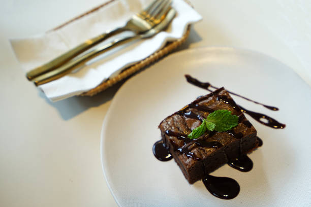 A slice of brownie with vanilla icecream on top.