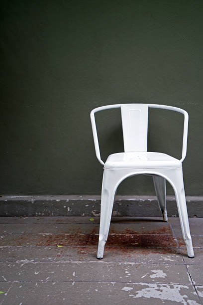 istock White metal chair with green wall 1369708185
