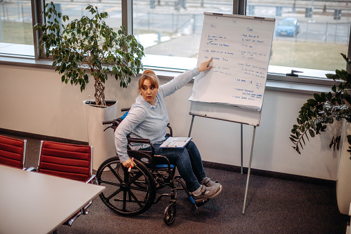 On a meeting with colleague in wheelchair planning activities and presenting results