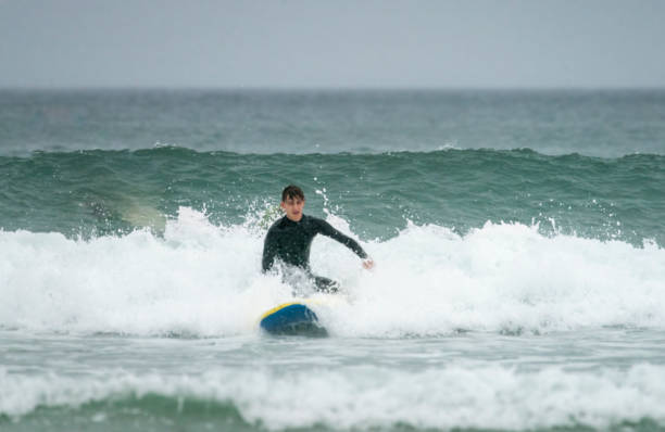 istock Young man surfing off the Cornish Coast 1369709372