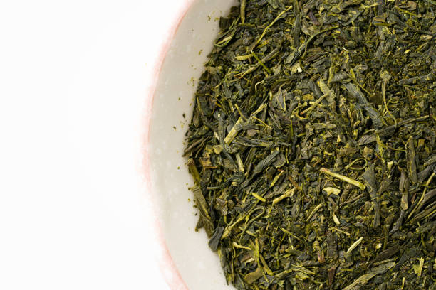 istock Dried green tea leaves on white background 1369710547