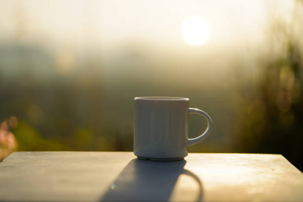 Coffee mug at sunset with empty blurred background