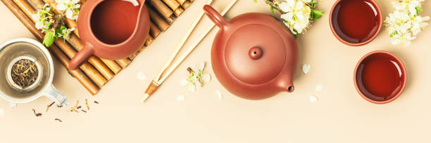 istock Asian Tea set on stone slate board, ceramic teapot, cups, dried tea and spring branches 1369710838