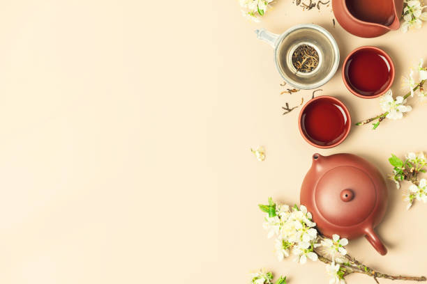 istock Asian Tea set on stone slate board, ceramic teapot, cups, dried tea and spring branches 1369710839
