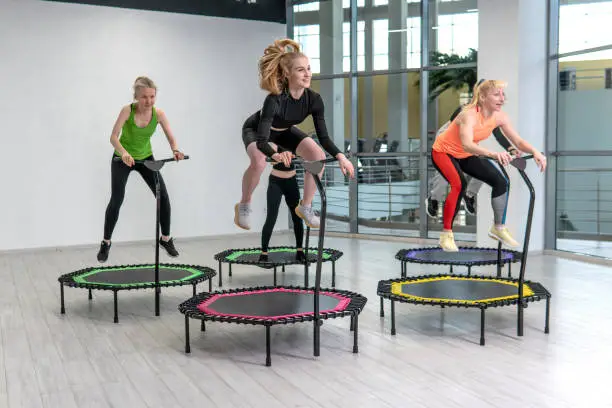 Trampoline for fitness girls are engaged in professional sports, the concept of a healthy lifestyle jumping trampoline woman fitness jump girl, for exercise health for female from energy wellness, club vitality. Instructor cute bounce, dance