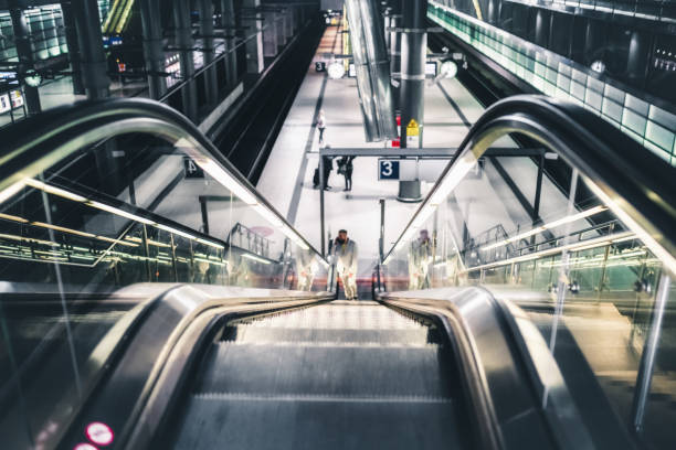 istock business man coming up illuminated escalator 1369712343