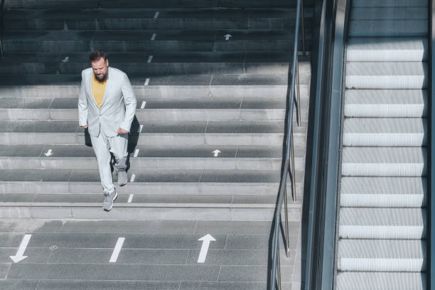 istock senior business man coming down stairs 1369712571