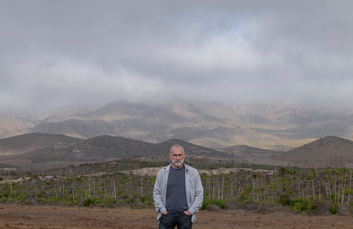 Adult man in jeans standing on field. Cabo de Gata Nature Park, Almeria, Spain