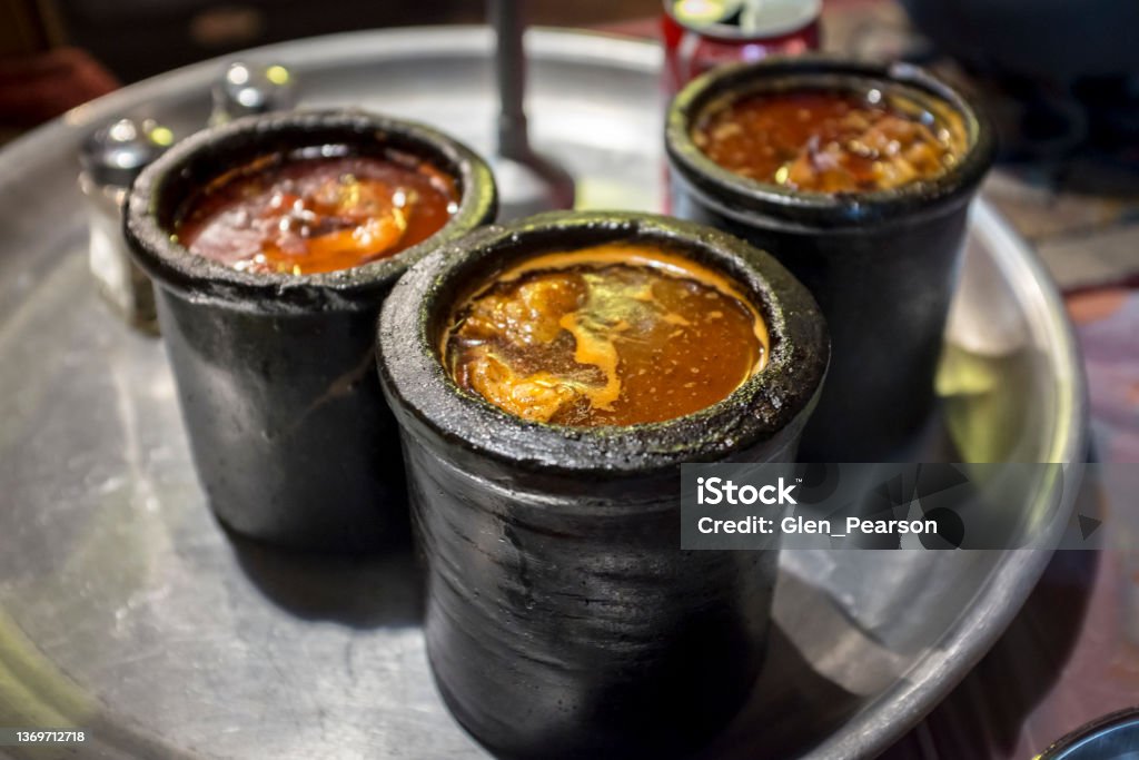 Three pots of Dizi Three pots of the tradtional Persian dish known as Dizi (also known as abgoosht). Dizi refers to the clay pot in which this lamb stew or broth is served. Bazaar Market Stock Photo