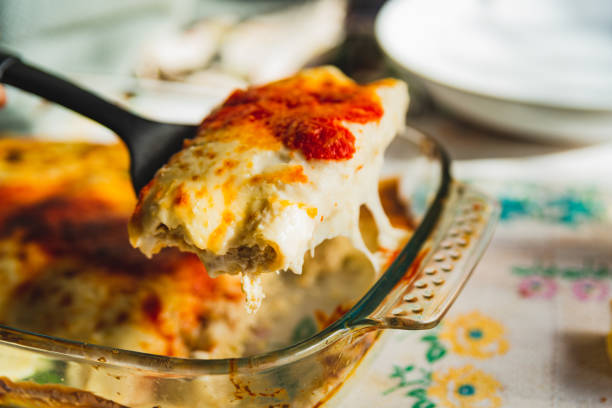 istock Cannelloni with spinach close up, tomato sauce, bachamel and cheese on table cloth with fork taking portion . Traditional homemade classic italian cuisine concept. 1369715511