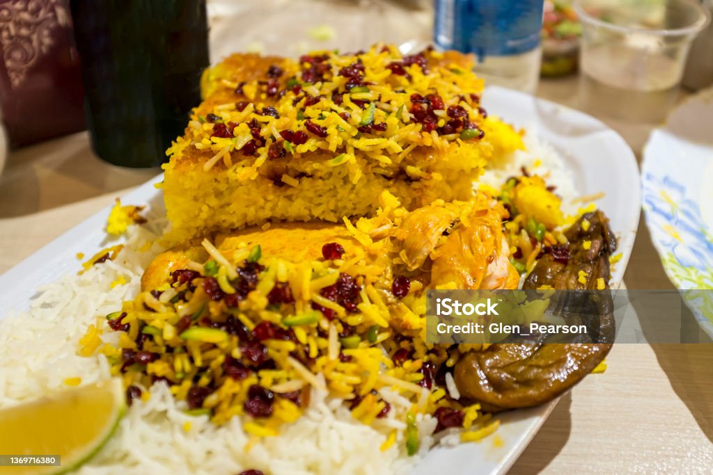 Tahchin with Chicken Tahchin with chicken, a famous rice dish with barberries, yoghurt, served with eggplant, in a restaurant in Tehran, Iran Bazaar Market Stock Photo